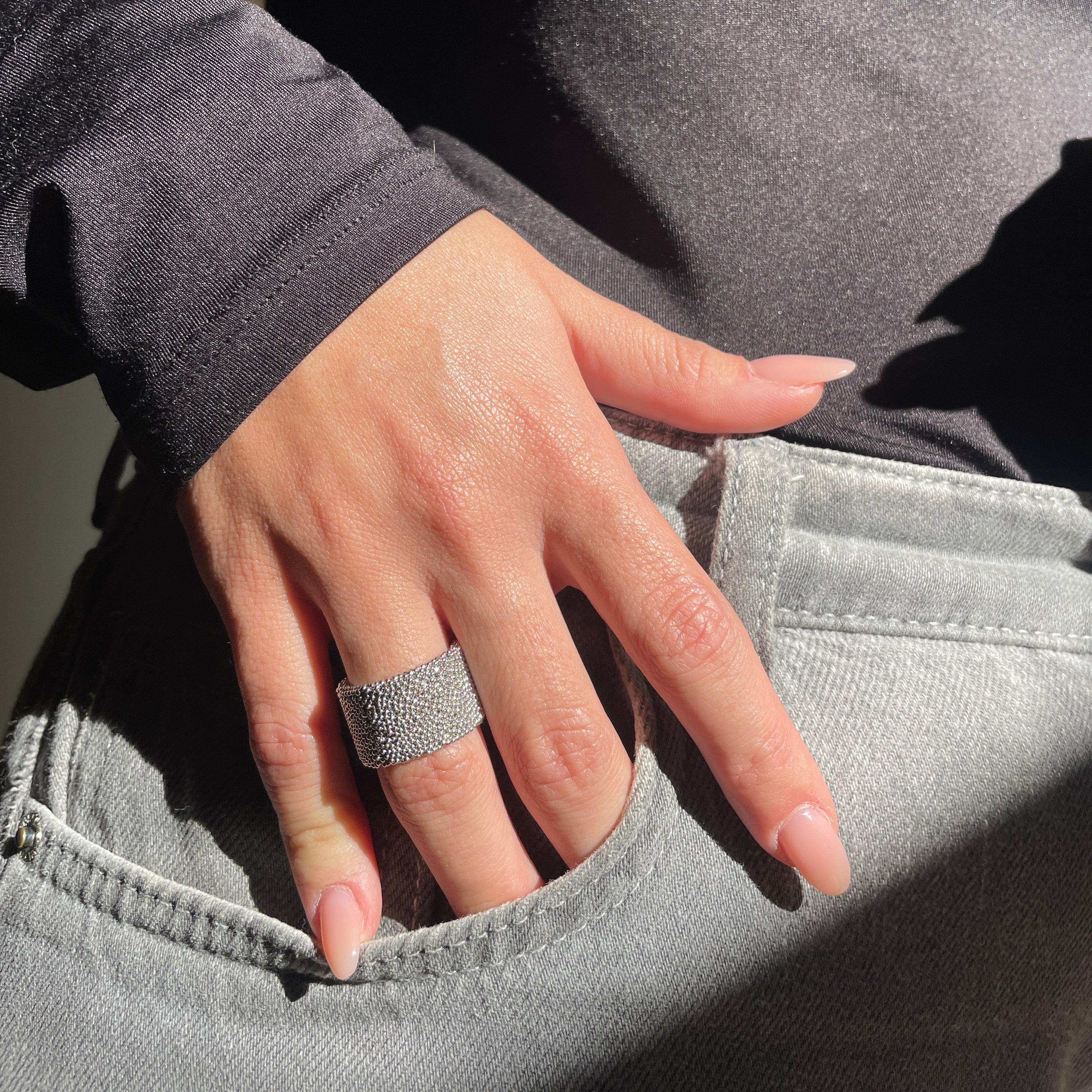 Anello a fascia 8911 indossato, texture materica in micro‑sfere di bronzo